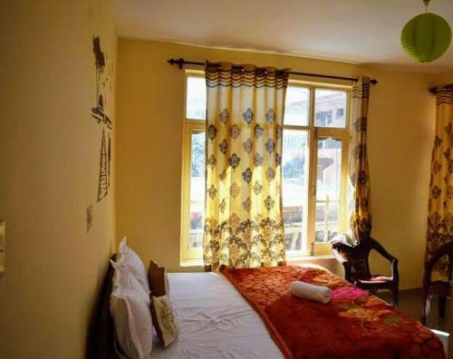 a bedroom with a bed in front of a window at Be Happy HomeStay in McLeod Ganj