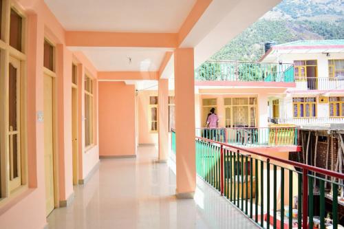 un pasillo en un edificio escolar con una mujer caminando por él en Be Happy HomeStay, en McLeod Ganj