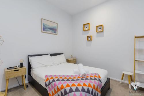 a bedroom with a bed with a colorful blanket at KOZYGURU WEST END 10 MINS TO CITY 1 BED APT + FREE PARKING QWE017 in Brisbane