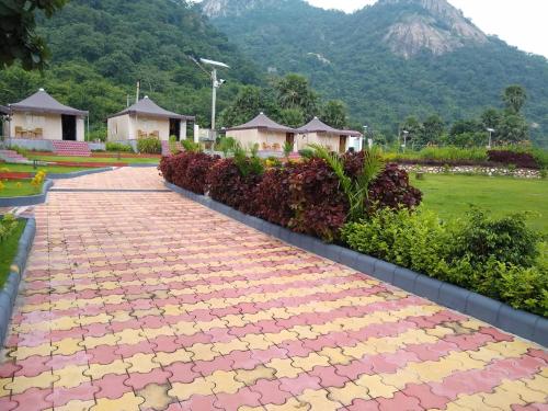 a brick walkway with a mountain in the background at Matha Forest Resort in Purulia