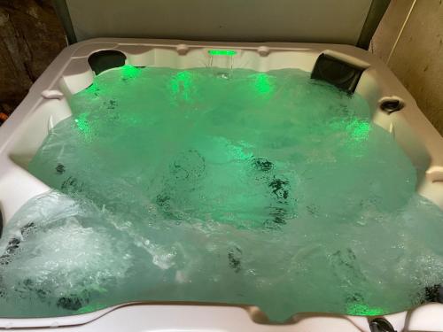 a bath tub filled with water with green lights at Françoise's Villa Luxury Hot Tub Mountain Ski - Munster in Luttenbach-près-Munster