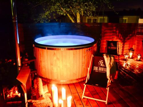 a large wooden tub sitting on a deck with candles at LUXURY CAMP - 150 m od Suntago Park in Grabce-Towarzystwo