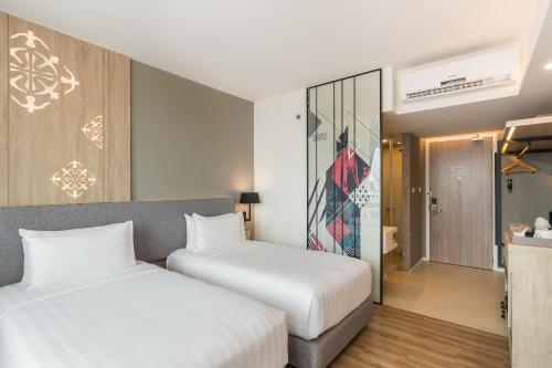 a hotel room with two beds and a corridor at Hotel Amber Pattaya in Pattaya Central