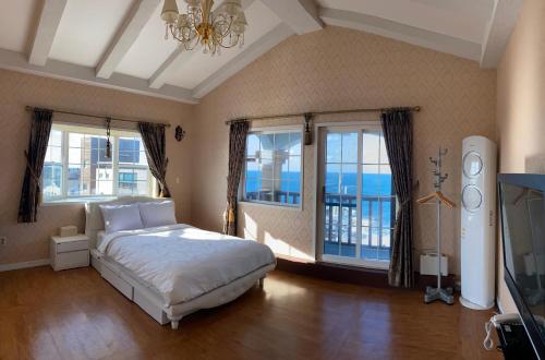 een slaapkamer met een bed en uitzicht op de oceaan bij Grim Resort in Jeju-stad