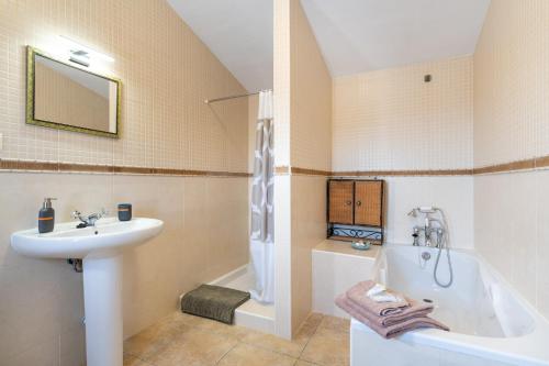 a bathroom with a sink and a bath tub at Hacienda la buena vida B&B en appartementen in Algarinejo