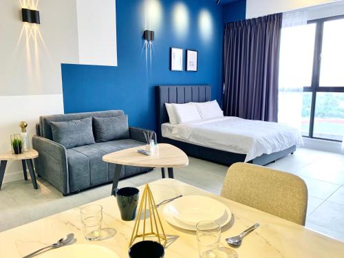 Habitación de hotel con cama, sofá y mesas en Bell Suites @ Sunsuria City, en Sepang