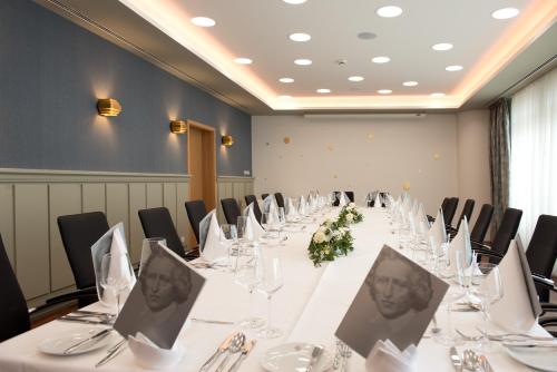 a conference room with a long table with tables and chairs at Hotel Gude in Kassel