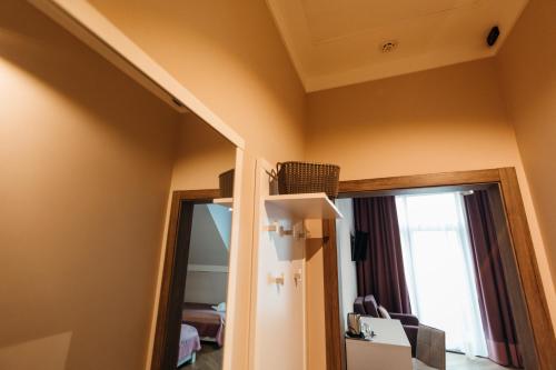 a room with a mirror and a room with a window at Nicole in Uzhhorod