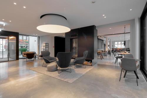 a lobby with chairs and a table and a fireplace at Domizil Tübingen in Tübingen