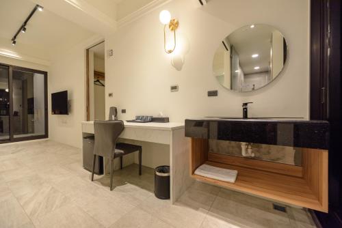 La salle de bains est pourvue d'un lavabo et d'un miroir. dans l'établissement Day Time Travel B&B 登記編號1033, à Magong