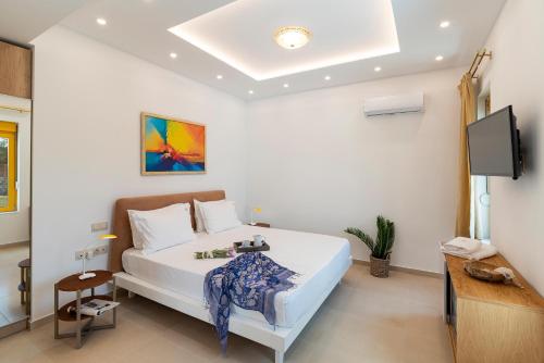 a bedroom with a bed and a flat screen tv at Serenity Villas in Kolimbia