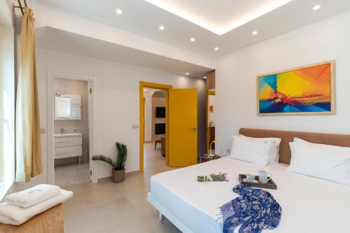 a bedroom with a white bed and a yellow wall at Serenity Villas in Kolimbia