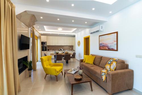 a living room with a couch and a yellow chair at Serenity Villas in Kolimbia