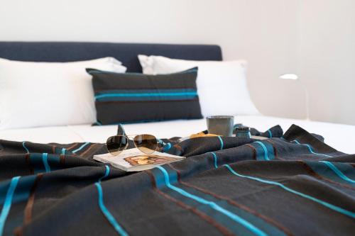 a bed with a pair of sunglasses and a book on it at Serenity Villas in Kolimbia