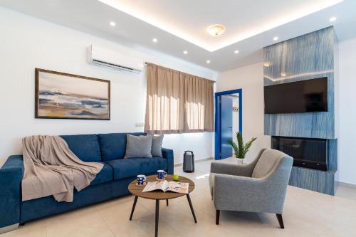 a living room with a blue couch and a chair at Serenity Villas in Kolimbia