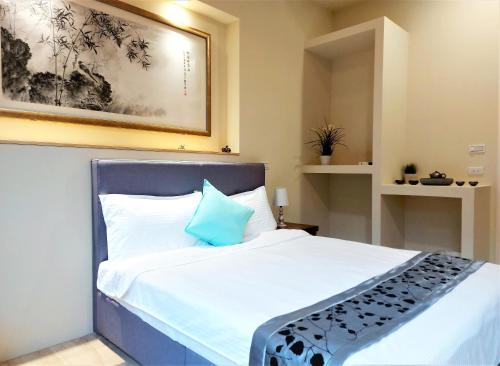a bedroom with a large bed with a blue pillow at Dosun B&B in Jiufen