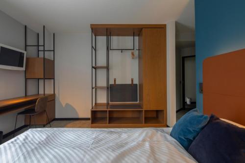 a bedroom with a bed and a tv and a desk at Domizil Tübingen in Tübingen