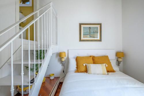 a white staircase with yellow pillows in a white room at Casa Pimpotta in Ravenna