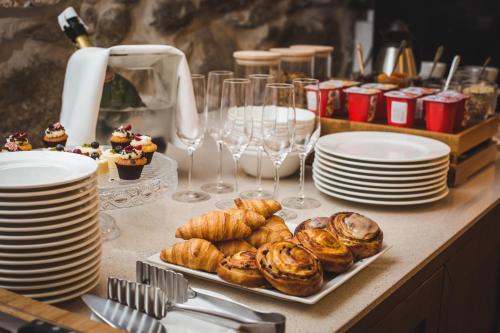 a table with plates and cups and pastries on it at Art Hotel Roma in Liepāja