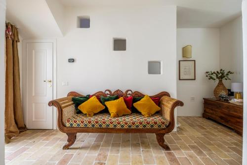 a couch with colorful pillows on it in a living room at Casa Pimpotta in Ravenna
