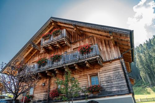 a wooden house with flower boxes on the side of it at Almwelt Austria in Schladming
