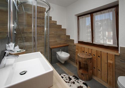 a bathroom with a sink and a shower and a toilet at Assietta in Sauze dʼOulx