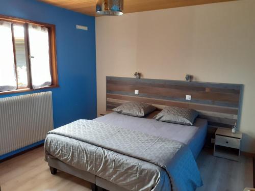 a bedroom with a large bed with a wooden headboard at Chalet Les Chardons in Gérardmer