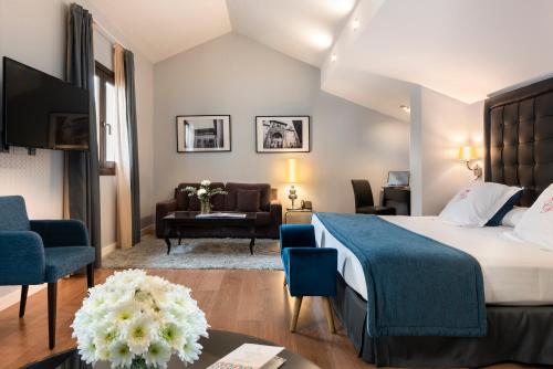 a hotel room with a bed and a living room at La Casa de la Trinidad in Granada