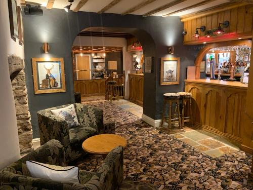 a bar with a couch and a table in a room at Ye Olde Punchbowl Country Inn & Gardens in Bridgnorth