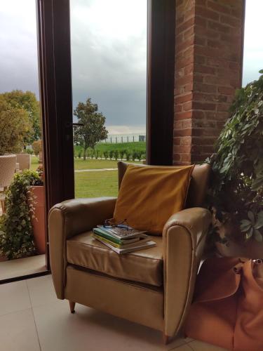 a brown couch with books on it in front of a window at Casa Lidia - ALLOGGI SMART in Breganze