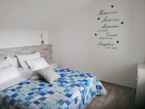 a bedroom with a bed and words on the wall at Apartment Villa Franci in Pag