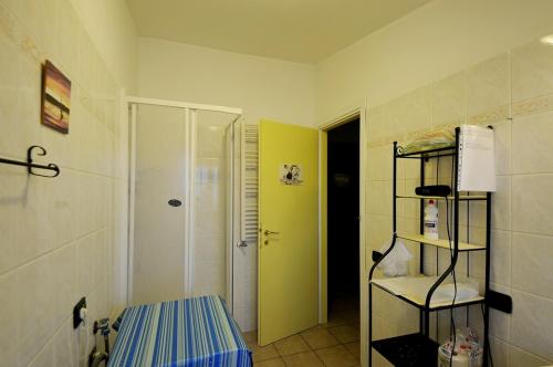 a bathroom with a shower and a yellow door at A La vue chambre BAGNO CONDIVISO SHARED BOTH2piano no lift no navetta a pagamento aria condizionata ed extra bed 3 MINUTI A PIEDI DA BUS PER FIERA DI ROMA in Fiumicino