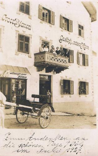 a group of people sitting on a balcony of a building at Gasthof Albergo Kreuzwirt in Fiè