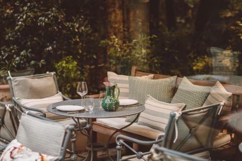 een tafel en stoelen met wijnglazen op een patio bij Hôtel de l'Abbaye in Parijs