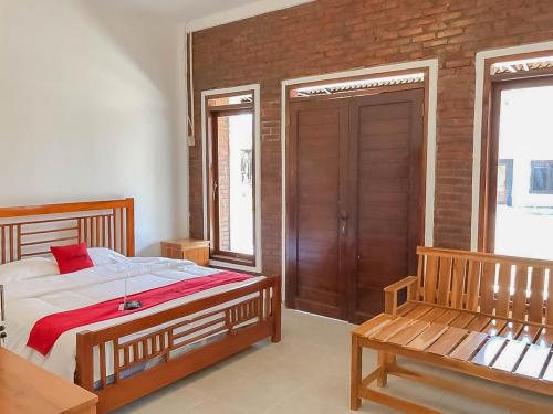 1 dormitorio con cama y banco. en RedDoorz Resort near Darajat Garut, en Garut