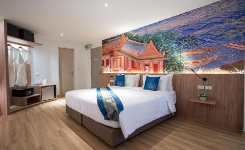 ein Schlafzimmer mit einem großen Bett und einem Gemälde an der Wand in der Unterkunft Pannarai Hotel Bangkok in Bangkok