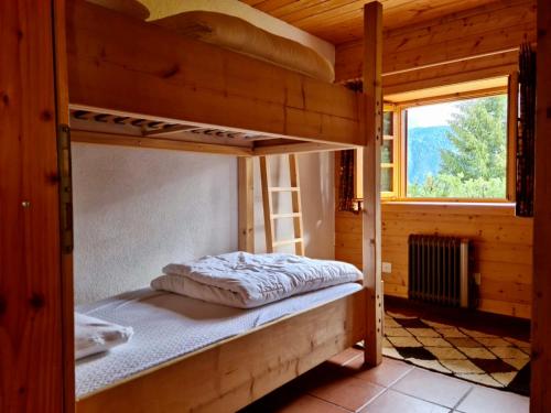 a bedroom with two bunk beds in a wooden cabin at Chalet Wulli in der Nähe der Skianlagen Savognin in Savognin