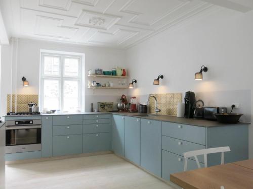 eine Küche mit blauen Schränken und einer weißen Decke in der Unterkunft ApartmentInCopenhagen Apartment 1267 in Kopenhagen