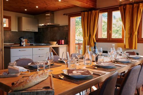 une longue table en bois avec des verres et des assiettes dans l'établissement Chalet ALPACA Peisey-Vallandry - Domaine Paradiski, à Peisey-Nancroix