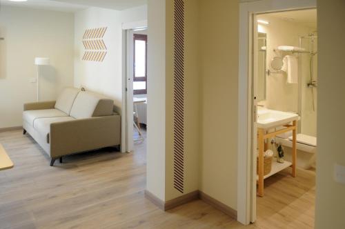 a living room with a couch and a sink at APARTAMENTOS TURÍSTICOS GUIANA in Ponferrada