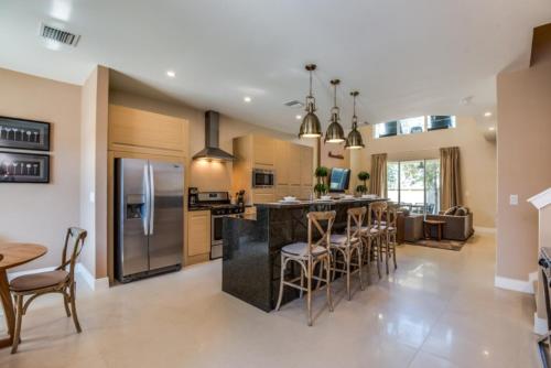 a kitchen with a bar with stools and a counter top at At Last You can Rent the Perfect Luxury Townhome on Magic Village Resort, minutes from Disney World, Orlando Townhome 3703 in Orlando