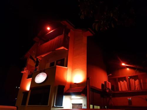 a building with a clock tower at night at Pensiunea Red Rose Apartments in Timişoara