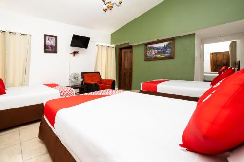 Cette chambre d'hôtel comprend 2 lits avec des oreillers rouges. dans l'établissement Hotel Villas De San Miguel Media Luna, à Río Verde