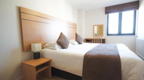A bed or beds in a room at Crompton House Apartments 