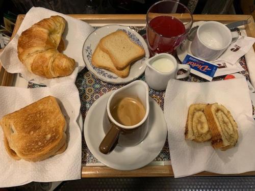 a tray of food with bread and coffee and croissants at Hotel Croce Di Malta in Rome