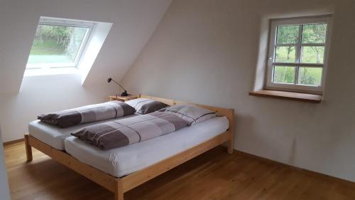1 cama en una habitación con 2 ventanas en Ferienhaus Sprink Vulkaneifel en Strohn