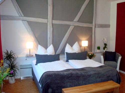 a bedroom with a large bed and two chairs at Pension "Westphal's" in Wismar