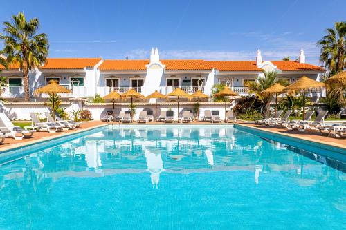 a swimming pool in front of a resort at Giramar Apartamentos Turisticos in Lagos