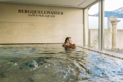 een vrouw in het water in een zwembad bij Hotel Goldener Ochs in Bad Ischl