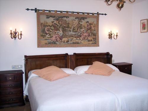 Hotel Azkue في جيتاريا: غرفة نوم بسريرين ولوحة على الحائط